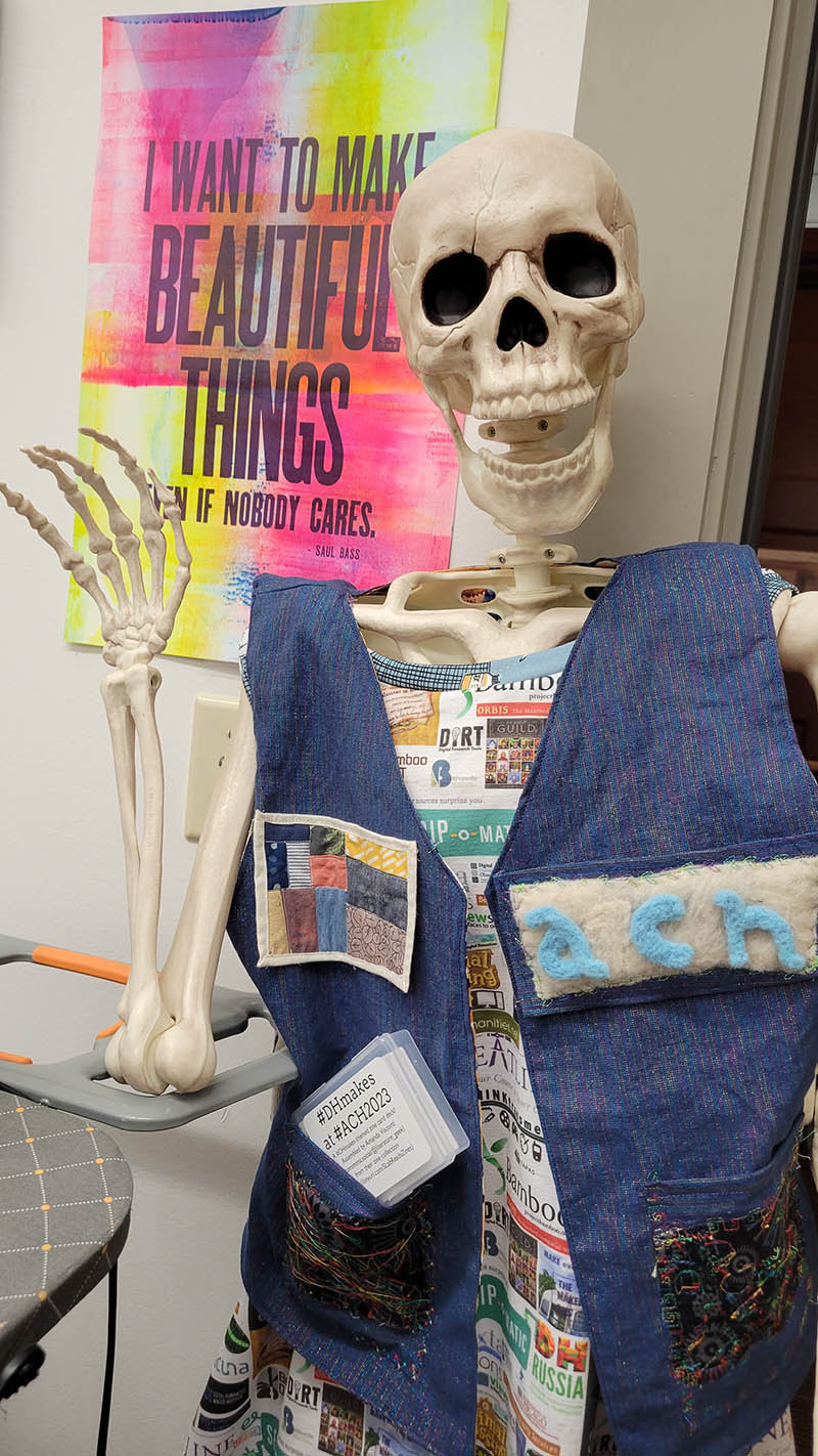 The Textile Makerspace mascot, a skeleton wearing a #DHMakes vest