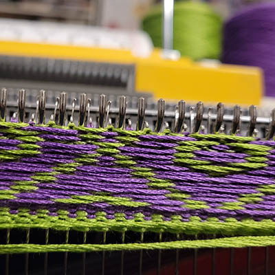 Punchcard knitting machine knitting a design